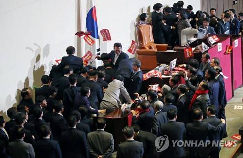 문희상 의장에게 손팻말 던지는 한국당 의원들 12월 27일 국회 본회의장에서 문희상 국회의장이 자유한국당 의원들의 저지를 뚫고 의장석으로 향하는 모습[연합뉴스 자료사진]