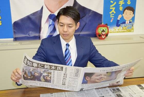 올해 4월 일본 지방선거에서 최연소 홋카이도 지사로 당선된 스즈키 나오미치(鈴木直道)가 자신의 당선 스토리를 실은 홋카이도신문을 읽고 있다. [사진=지지통신 제공]