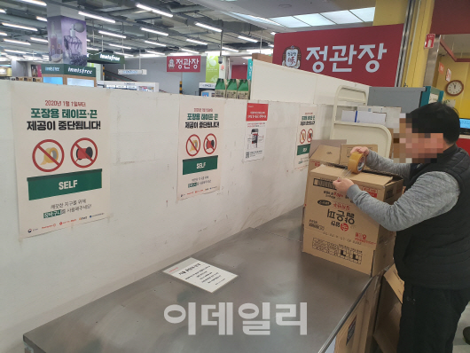 2일 오전 서울 영등포구 한 대형마트에서 장을 보 시민이 직접 가져온 테이프로 포장을 하고 있다.(사진=최정훈 기자)