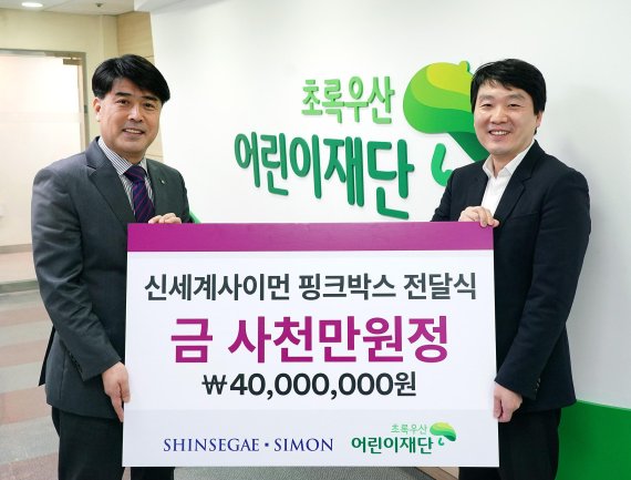 9일 신세계사이먼 정원철 CSR팀장(오른쪽)이 초록우산어린이재단 이형진 서울북부지역본부장에게 4000만원 상당의 핑크박스를 전달하고 있다. 신세계사이먼제공