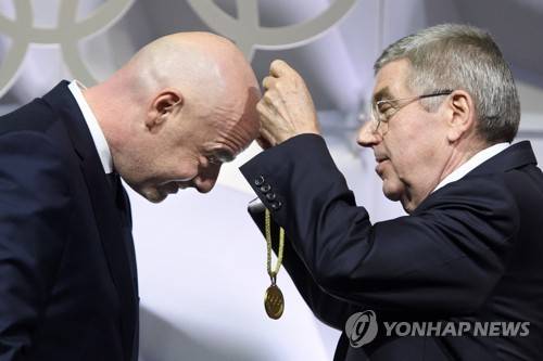 인판티노 FIFA 회장에게 IOC 신규 위원 메달 걸어주는 바흐 IOC 위원장 토마스 바흐 국제올림픽위원회(IOC) 위원장이 10일(현지시간) 스위스 로잔에서 열린 IOC 총회에서 새로 IOC 위원으로 선출된 잔니 인판티노 국제축구연맹(FIFA) 회장에게 메달을 걸어주고 있다. [EPA=연합뉴스]