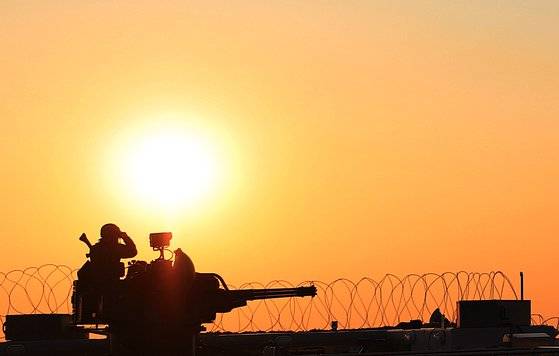 지난 14일 서울 고층빌딩 건물에 위치한 방공 진지 장병 뒤로 해가 넘어가고 있다. 이들은 365일 24시간 항상 같은 위치에서 경계 태세를 지속한다. [박용한 기자]