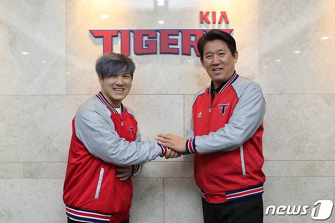 KIA 타이거즈 김선빈이 14일 광주-기아 챔피언스 필드 구단 사무실에서 FA 계약을 체결한 뒤 조계현 단장과 악수하고 있다.(KIA 타이거즈 제공). © 뉴스1