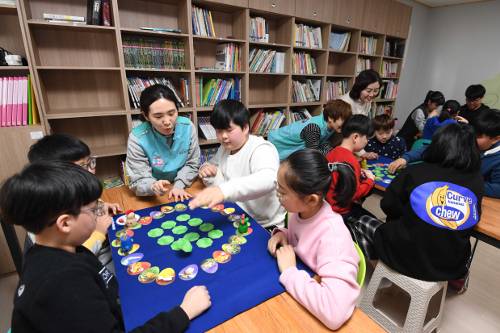 건보공단 건이강이봉사단원들과 아이들이 지난 17일 꾸매그린아동지원센터에서 열린 건보공단 주최 ‘설명절맞이 사회공헌활동 집중봉사’에서 방과후 체험교실 프로그램인 보드게임을 하고 있다.