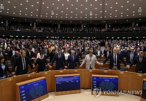 유럽의회 의원들이 29일(현지시간) 벨기에 브뤼셀에서 열린 본회의에서 브렉시트 협정 표결 뒤 손을 맞잡고 있다 [로이터=연합뉴스]
