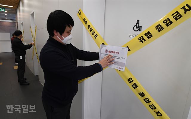6일 오후 신종 코로나바이러스 감염증(우한 폐렴) 확진 판정(20번째) 환자가 근무한 것으로 확인된 서울 영등포구 GS홈쇼핑 본사에서 관계자들이 폐쇄 안내판을 붙이고 있다. 배우한 기자