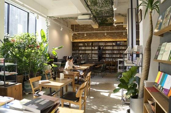 용인 ‘생각을담는집’. 1층은 북카페, 3~4층은 숙소로 사용한다. 큼지막한 창과 수많은 화초 덕에 온실처럼 아늑한 분위기다.