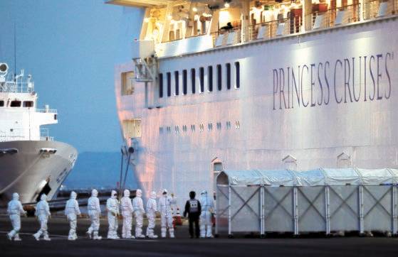 방호복을 입은 일본 방역당국 관계자들이 지난 7일 일본 요코하마항에 정박 중인 크루즈 다이아몬드 프린세스에 오르고 있다. [로이터=연합뉴스]