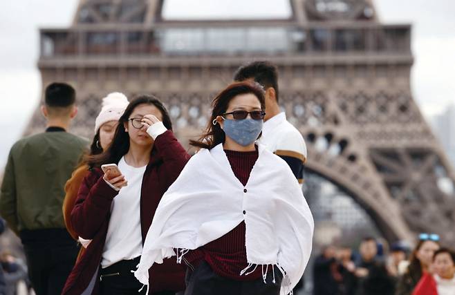 한 중국인 여성이 2월1일(현지시간) 마스크를 착용하고 프랑스 파리 에펠탑 앞을 지나가고 있다. ⓒ연합뉴스