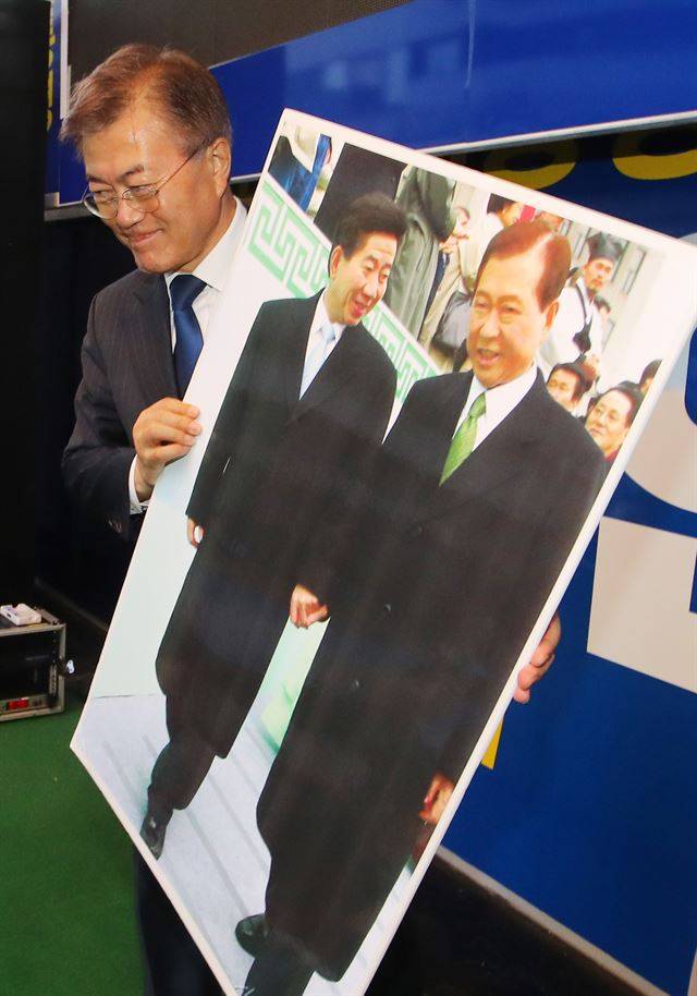 2017년 대선을 앞두고 문재인 더불어민주당 대선후보가 광주 충장로에서 열린 집중유세에서 선물 받은 김대중ㆍ노무현 전 대통령의 사진을 들어 보이고 있다. 한국일보 자료사진