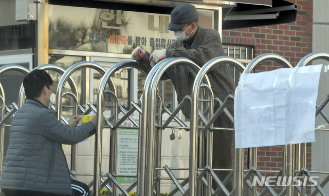 [광주=뉴시스] 류형근 기자 = 신종 코로나 바이러스 감염증(코로나19) 확진판정을 받은 교사가 학교를 들른 것으로 확인돼 폐쇄된 가운데 학교 관계자들이 23일 오후 광주 남구 진월초등학교 교문에 통제 안내문을 걸고 있다. 2020.02.23. hgryu77@newsis.com