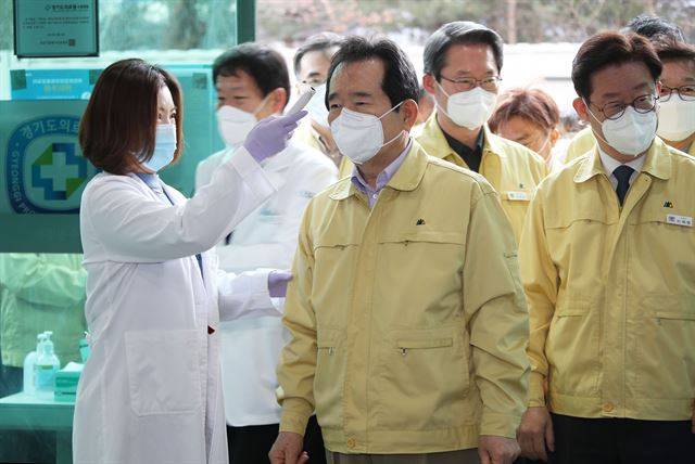 [코로나19] 정세균 국무총리가 8일 경기 수원시 장안구의 선별진료소를 방문해 체온을 측정하고 있다. 오른쪽은 이재명 경기도 도지사. 연합뉴스