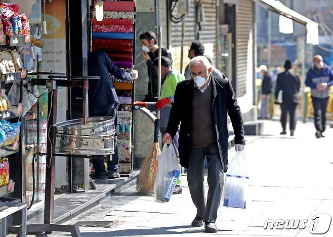 이란 수도 테헤란 길거리에 마스크를 쓴 시민들이 다니고 있다. © AFP=뉴스1