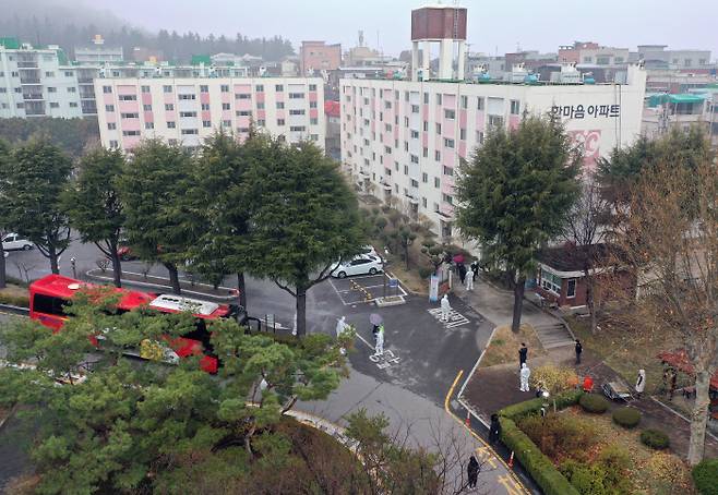 코로나19 확진 판정을 받은 대구시 달서구 한마음 아파트 주민들이 8일 오전 의료진 안내를 받아 생활치료센터에 가는 버스로 이동하고 있다.    연합뉴스