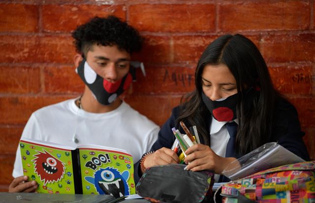훌리오 세사르 투르바이 학교 재학생 두 명이 11일 같은 천을 재활용해 만든 마스크를 쓰고 공부하고 있다. 소아차=AFP 연합뉴스