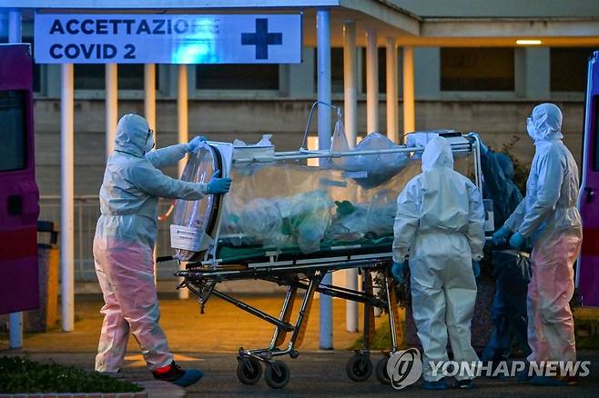 로마 임시병원에 수용되는 코로나19 중증 환자 (로마 AFP=연합뉴스) 이탈리아 로마의 게멜리 병원이 신종 코로나바이러스 감염증(코로나19)에 대처하기 위해 신설한 콜룸부스 2호 임시병원에서 16일(현지시간) 방호복을 입은 의료진이 들것을 이용해 중증 환자를 옮기고 있다. jsmoon@yna.co.kr