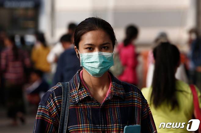 미얀마 양곤의 거리에서 한 여성이 마스크를 쓴 채 걷고 있다. © AFP=뉴스1