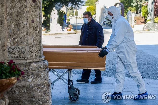 코로나19 사망자 몰려드는 이탈리아 공동묘지 (베르가모 AFP=연합뉴스) 이탈리아 롬바르디아 주 베르가모에서 신종 코로나바이러스 감염증(코로나19) 인명 피해가 극심한 가운데 16일(현지시간) 베르가모 공동 묘지에 도착한 장의사가 마스크와 방호복을 착용한 채 사망자의 관을 옮기고 있다. 베르가모에서는 30분마다 1명꼴로 코로나19 희생자가 매장되고 있다. jsmoon@yna.co.kr