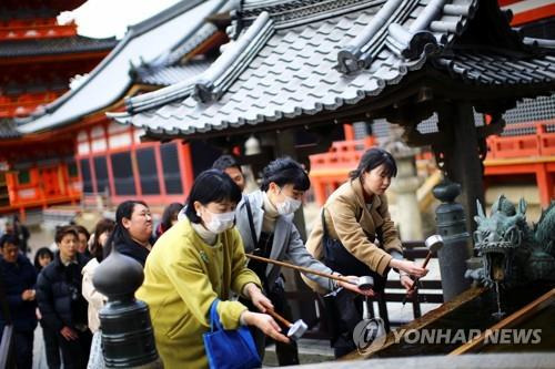 (교토 로이터=연합뉴스) 15일 일본 교토(京都)시 소재 사찰인 기요미즈데라(淸水寺)에서 마스크를 쓴 방문객이 물로 손을 씻고 있다. 2020.3.19