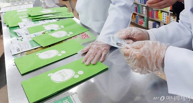 한주에 1인 2장으로 제한되는 '마스크 5부제' 시행 첫 날인 9일 오후 서울 종로구의 한 약국에서 신분증 확인을 하고 있다. / 사진=김휘선 기자 hwijpg@