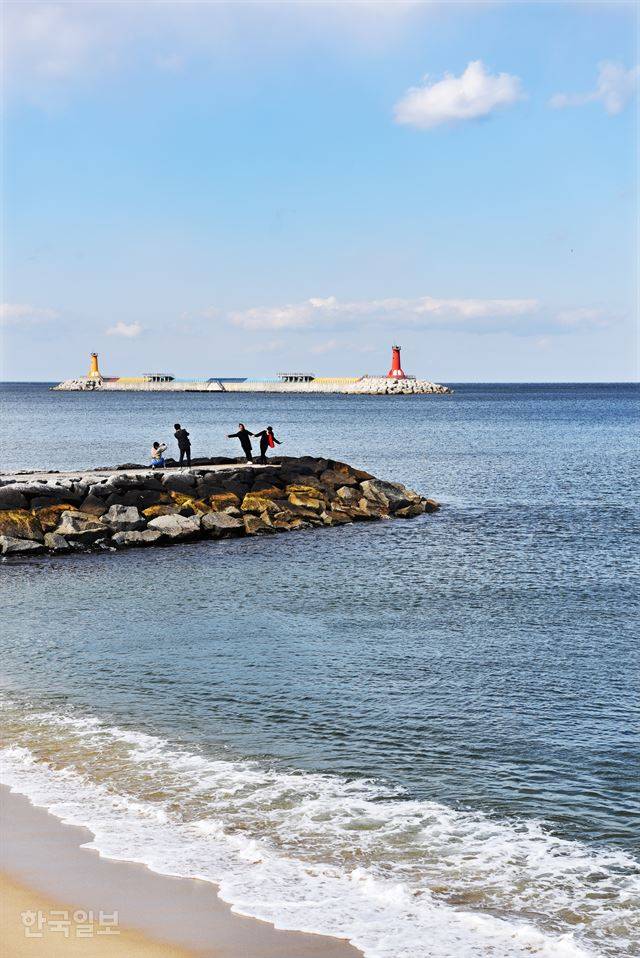 가족 여행객이 주문진 방사제에서 사진을 찍고 있다.