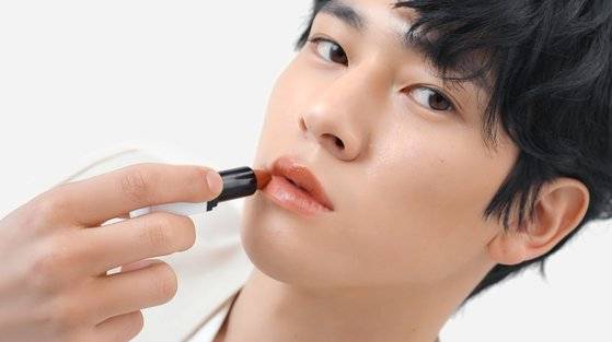 남녀 구분없이 함께 쓰는 콘셉트의 젠더뉴트럴 화장품 '라카'의 CF 장면. 남성 모델이 립스틱을 바르며 포즈를 취하고 있다. 사진 라카