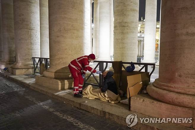 로마 노숙인 코로나19 체온 측정하는 자원봉사자 (로마 AP=연합뉴스) 이탈리아 적십자 자원봉사자가 25일(현지시간) 로마 성 베드로 광장에서 신종 코로나바이러스 감염증(코로나19) 진단을 위해 한 노숙인의 체온을 측정하고 있다. ucham1789@yna.co.kr