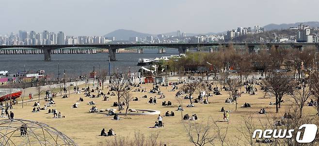 27일 오후 서울 여의도 한강공원에서 시민들이 봄날씨를 만끽하고 있다. 이날 정부는 이번 주말 야외활동을 자제하고 사회적 거리두기에 동참해 줄 것을 호소했다. 2020.3.27/뉴스1 © News1 박지혜 기자