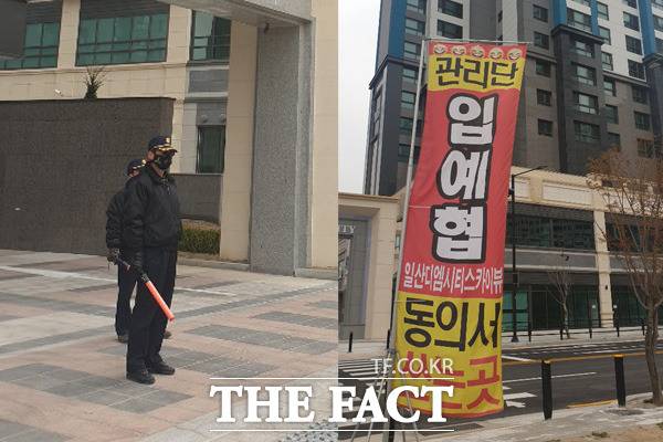 '일산디엠시티스카이뷰' 관리비를 두고 시공사인 대방건설과 입주예정자협의회 간 마찰이 지속하고 있다. 사진은 대방건설 협력 관리업체 대덕하우징씨스템 경비요원(왼쪽)과 입주예정자협의회 현수막 모습. /윤정원 기자