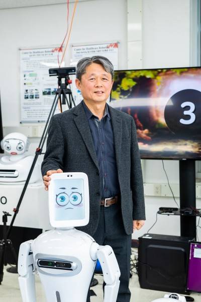 김문상 GIST 헬스케어로봇센터장이 연구실에서 개발한 자폐스펙트럼증후군 어린이를 위한 놀이 치료 로봇과 함께 자세를 취했다. 인공지능(AI)기술과 로보틱스가 결합한 로봇은 최근 다양한 질병을 보다 환자 친화적으로 치료할 대안으로 주목 받고 있다. 동아사이언스 제공