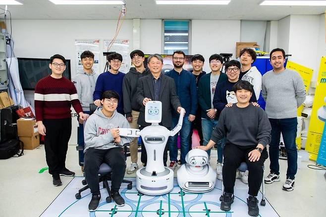 GIST 헬스케어로봇센터 연구실에서 김문상 센터장(가운데)과 연구원들이 자폐스펙트럼증후군 어린이를 위한 놀이 치료 로봇과 함께 자세를 취했다. 인공지능(AI)기술과 로보틱스가 결합한 로봇은 최근 다양한 질병을 보다 환자 친화적으로 치료할 대안으로 주목 받고 있다. 동아사이언스 제공
