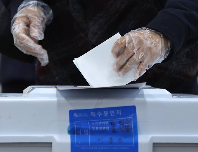 제21대 국회의원 선거 사전투표 첫날인 10일 오전 서울 종로구 가회동 주민센터에서 한 시민이 코로나19 예방을 위해 비닐 장갑을 착용하고 투표하고 있다. 역대 최고의 사전투표율을 보인 이번 총선 사전투표는 10~11일 이틀간 전국 3508개 투표소에서 진행됐다. [연합]