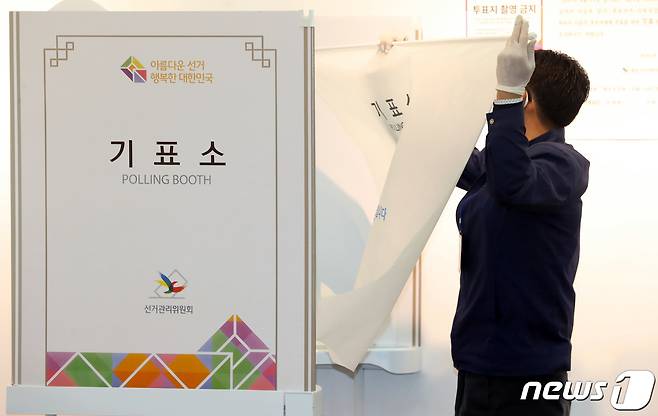 투표소 관계자가 15일 서울 종로구 혜화동 제3투표소에서 황교안 미래통합당 종로구 후보의 요구로 가림막을 설치하고 있다. 2020.04.15 /뉴스1 © News1 김명섭 기자