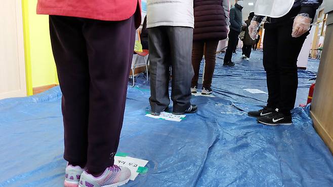 투표소에서 유권자들이 거리를 둔 채 줄을 서 있다.