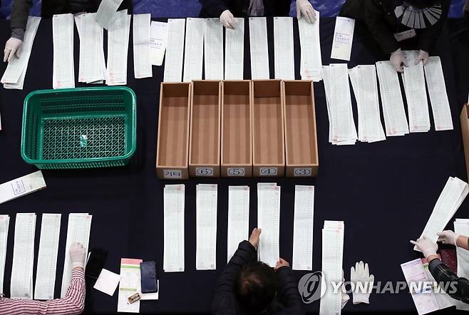 수작업으로 (서울=연합뉴스) 홍해인 기자 = 15일 오후 서울 종로구 경복고등학교에 마련된 투표소에서 개표요원들이 비례대표 투표용지를 수개표하고 있다. 2020.4.15 hihong@yna.co.kr