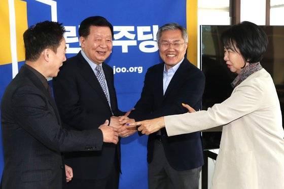 이근식 열린민주당 대표와 최강욱 국회의원 당선인이 20일 오전 서울 여의도 중앙당사에서 열린 최고위원회의에서 악수를 나누고 있다. 이날 최고위원회의에서 최강욱 당선인이 정식으로 비상대책위원장으로 임명되면, 당의 전권을 맡아 내달 중순에 열릴 전당대회 준비 등 당무를 맡을 전망이다. 왼쪽부터 정봉주 최고위원, 이근식 대표, 최강욱 당선인, 손혜원 최고위윈. [뉴스1]