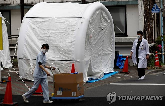 도쿄 병원 밖에 설치된 코로나19 검사텐트 (도쿄 로이터=연합뉴스) 일본 도쿄 카와키타 종합병원 야외에 신종 코로나바이러스 감염증(코로나19) 검사를 위해 설치된 텐트들 옆으로 17일 의료 관계자들이 지나가고 있다. leekm@yna.co.kr