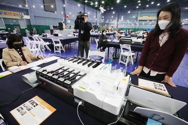 제21대 국회의원선거를 하루 앞둔 14일 서울 영등포구 다목적 배드민턴체육관에 마련된 개표소에서 개표사무원이 투표지 분류기를 점검하고 있다. 연합뉴스
