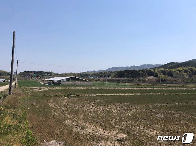 바로 앞에 보이는 땅이 마을 이장 동의서가 없다는 이유로 축사 건축허가가 불허된 지역. 그 옆으로 150m 떨어진 곳에 신축된 축사. 또한 저멀리 마을이 보이고 있다. /© 뉴스1