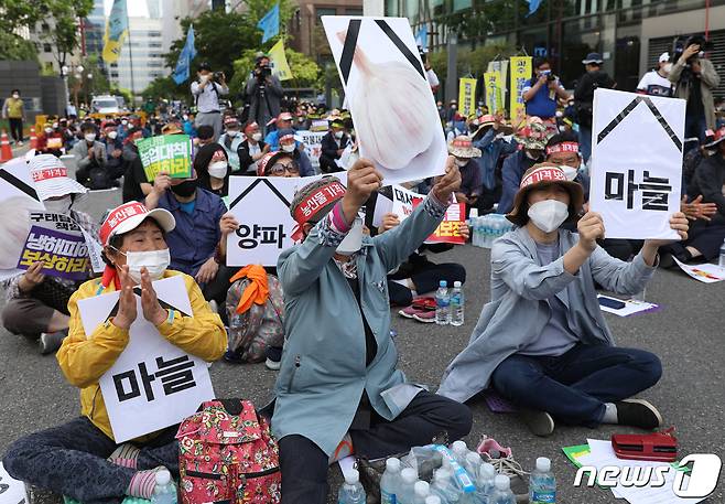 7일 오후 서울 여의도 국회 앞에서 열린 전국농민대회에서 농민들이 농업 대책을 마련하라는 구호를 외치고 있다. 이들은 올해 마늘과 양파 농가는 신종 코로나바이러스 감염증(코로나19) 사태와 이상기후로 인한 냉해 피해 등으로 농가들이 피해를 입었다며 정부의 대책 마련을 촉구했다. 2020.5.7/뉴스1 © News1 신웅수 기자