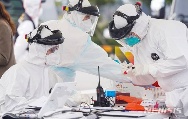 [제주=뉴시스] 강정만 기자= 제주국제공항 내 야외 주차장에 설치된 워킹 스루 진료소에서 검사요원들이 한 도민의 검체를 확인하고 있다. 2010.03.30 (사진= 제주도제공)   photo@newsis.com