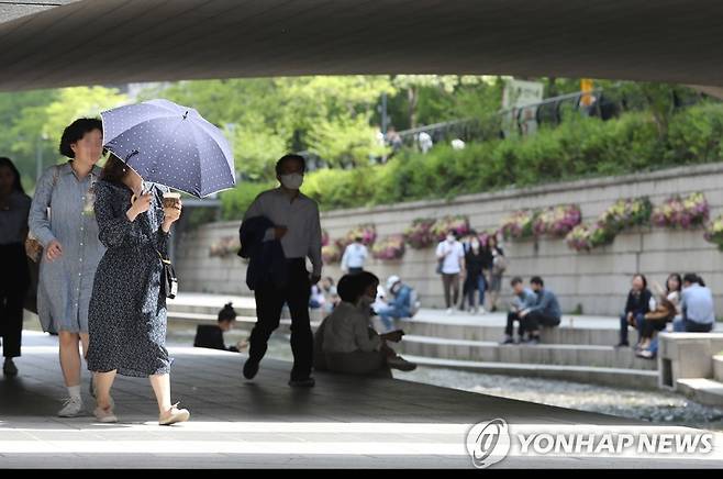 더운 날씨에 양산 등장 서울 낮 최고 기온이 26도를 기록한 지난 4일 오후 서울 청계천에서 양산을 든 시민이 걸어가고 있다. [연합뉴스 자료사진]