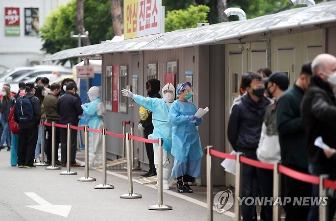 다시 뛰는 의료진 (서울=연합뉴스) 임헌정 기자 = 이태원 클럽발 신종 코로나바이러스 감염증(코로나19) 감염이 확산하는 가운데 12일 서울 용산구 순천향대 부속 서울병원 선별진료소에서 시민과 외국인들이 검사를 기다리고 있다. kane@yna.co.kr