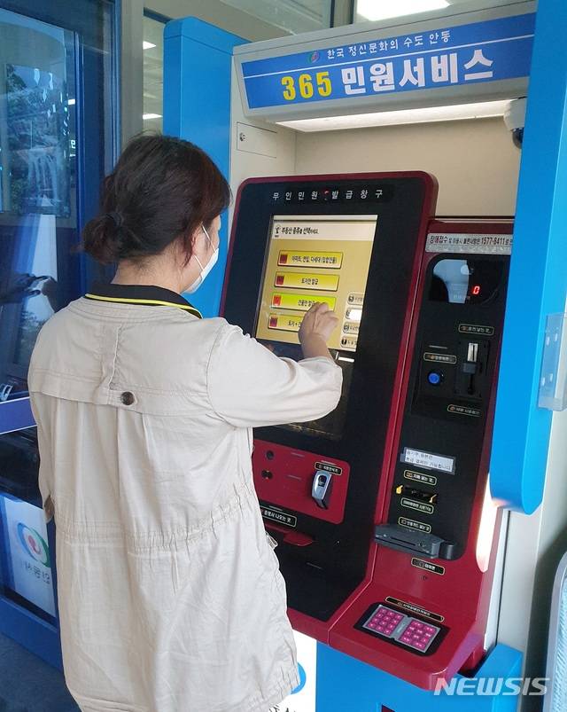 [안동=뉴시스] 김진호 기자 = 한 시민이 무인민원발급기를 이용해 서류를 발급 받고 있다. (사진=안동시 제공) 2020.05.17  photo@newsis.com