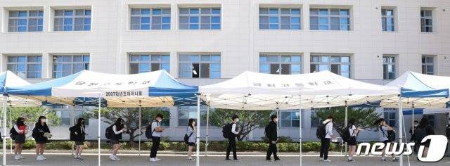 (청주=뉴스1) 고등학교 3학년 등교 개학이 시작된 20일 오전 충북 청주시 상당구 금천고등학교에서 학생들이 체온 검사를 위해 거리를 두고 서 있다. 2020.5.20/뉴스1