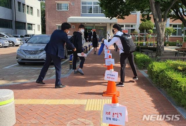 [대구=뉴시스]이은혜 기자 = 2차 등교 개학 첫날인 27일 오전 대구 수성구 범어동 동도중학교에서 한 학생이 오랜만에 만난 교사와 반갑게 인사를 나누고 있다. 2020.05.27. ehl@newsis.com