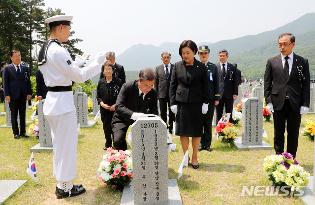 [대전=뉴시스]배훈식 기자 = 문재인 대통령과 김정숙 여사가 6일 대전 유성구 국립대전현충원에서 제65회 현충일 추념식을 마친 뒤 故 김필달 대령 묘역을 참배하고 있다. 2020.06.06. dahora83@newsis.com