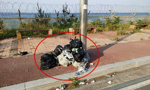 지경리 해수욕장 인근 해안도로에 버려진 쓰레기가 잔득 쌓여 있는 모습.