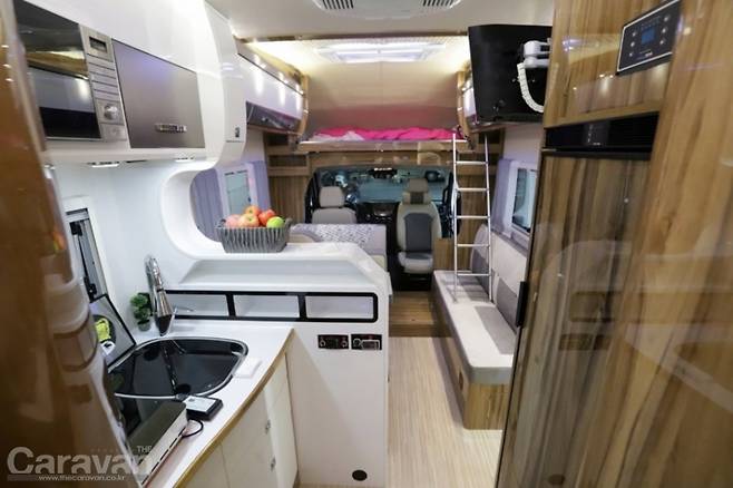 주방에서 바라보는 전면부, 리빙룸과 벙커베드를 갖춘 전형적인 유럽 모터홈을 연상시킨다