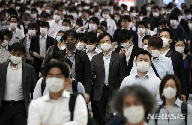 [도쿄=AP/뉴시스]지난달 26일 일본 도쿄의 한 지하철 역이 마스크를 쓴 채 출근하는 사람들로 붐비고 있다.